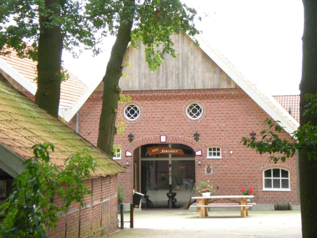 a red brick building with a picnic table in front of it at Erve Höwerboer in Ootmarsum