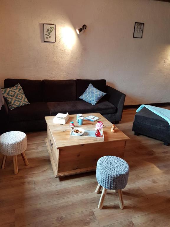 ein Wohnzimmer mit einem Sofa und einem Couchtisch in der Unterkunft Le Logis De Judicael in Paimpont