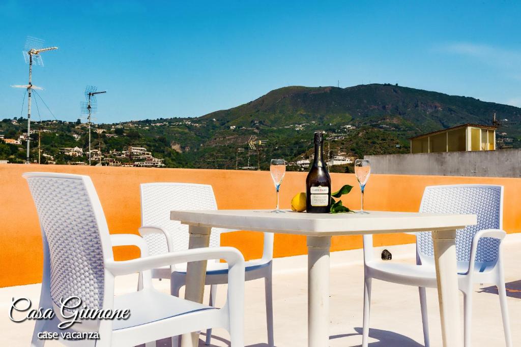 a white table and chairs with a bottle of wine at Casa Giunone in Lipari