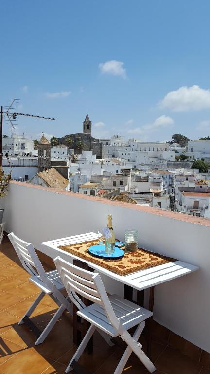 a table and chairs on a balcony with a view of a city at Holiday home La Atalaya de Vejer in Vejer de la Frontera