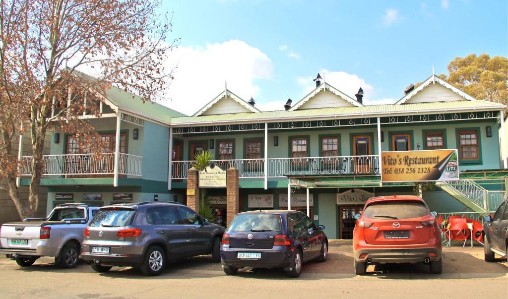 a group of cars parked in front of a building at Red Mountain House in Clarens