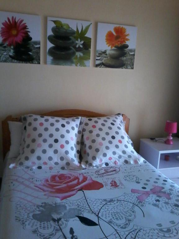 uma cama com almofadas de bolinhas e fotografias na parede em Chez Cozy's em Albion