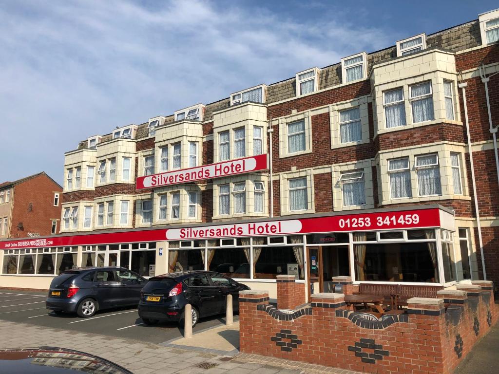 un edificio con coches estacionados frente a él en Silversands Hotel, en Blackpool