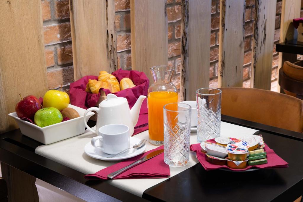 a table with a tray of fruit and a jug of orange juice at Hotel Paganelli in Venice