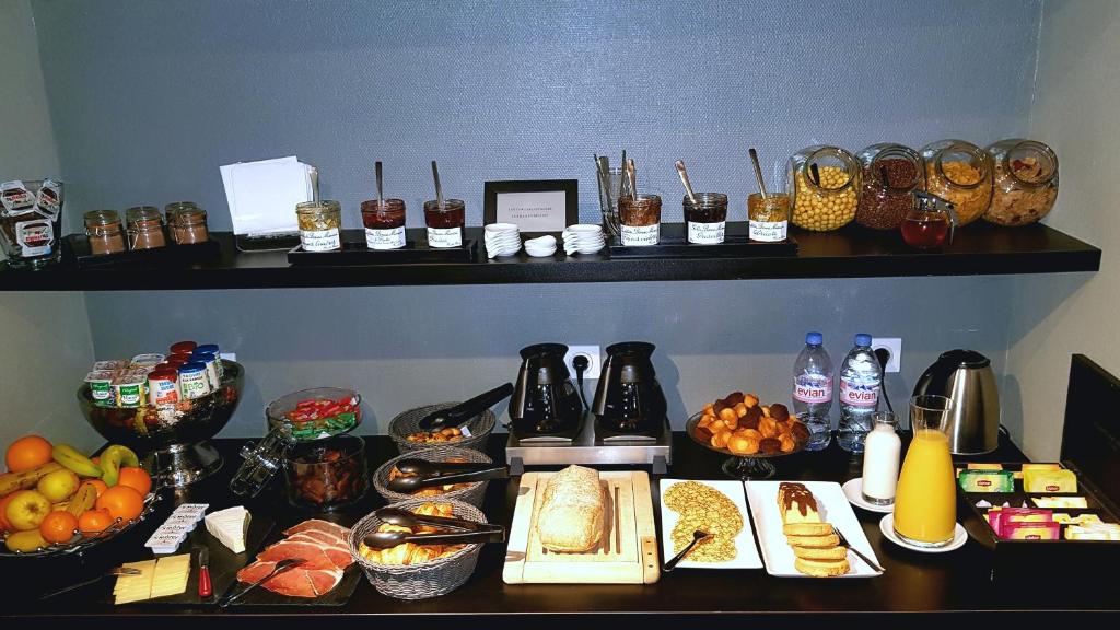 une table contenant de nombreux types de denrées alimentaires différents dans l'établissement Astrid Hotel, à Rennes