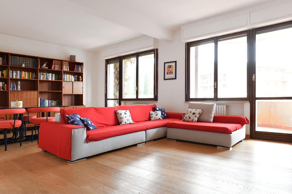un soggiorno con divano rosso e alcune finestre di La Casa nel Golfo dei Poeti a San Terenzo