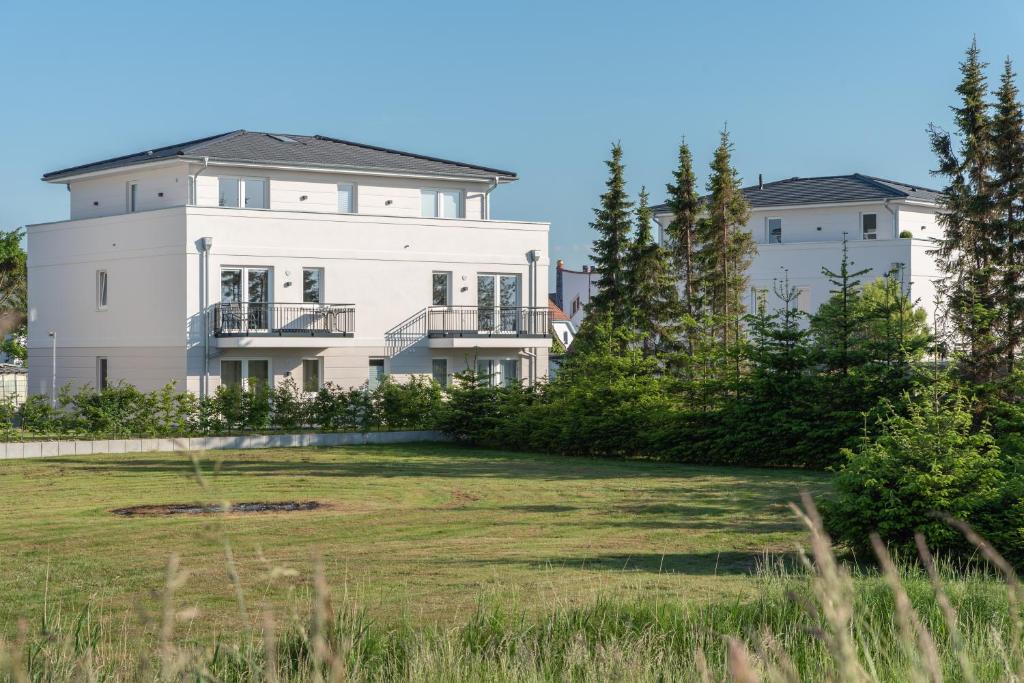 a large white house with a yard at Ferienwohnungen Rosengarten in Börgerende-Rethwisch