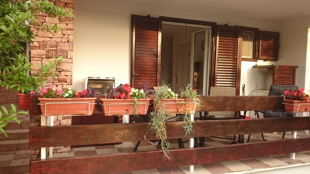 een veranda met potplanten op een hek bij BG apartman in Sutomore