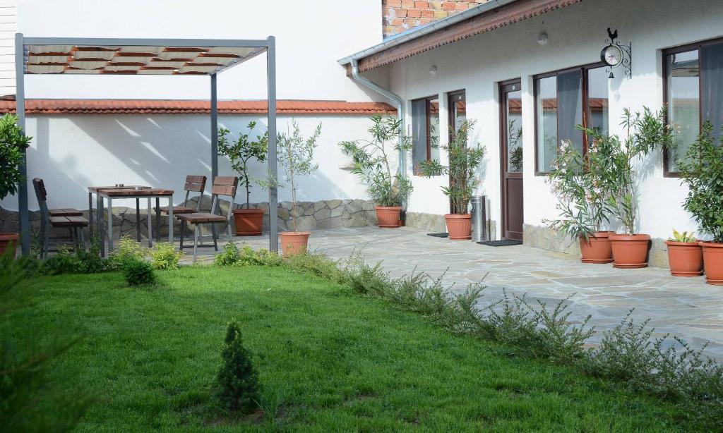 a patio outside of a house with potted plants at Guest House Dar in Tryavna