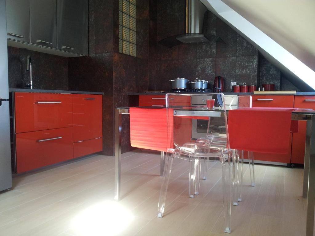 ルブリンにあるPod Zamkiem 2 sypialnie, salon, 70 m, komfort, max 8 osのキッチン(赤いキャビネット、テーブル、赤い椅子付)