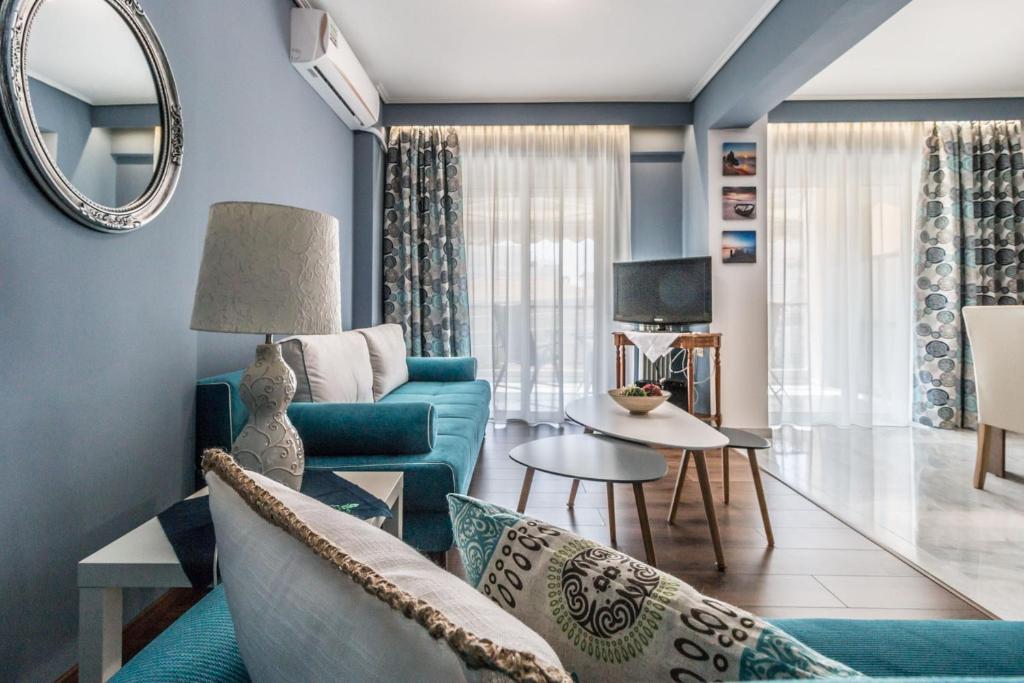 uma sala de estar com um sofá azul e um espelho em Boutique Mare Apart em Volos
