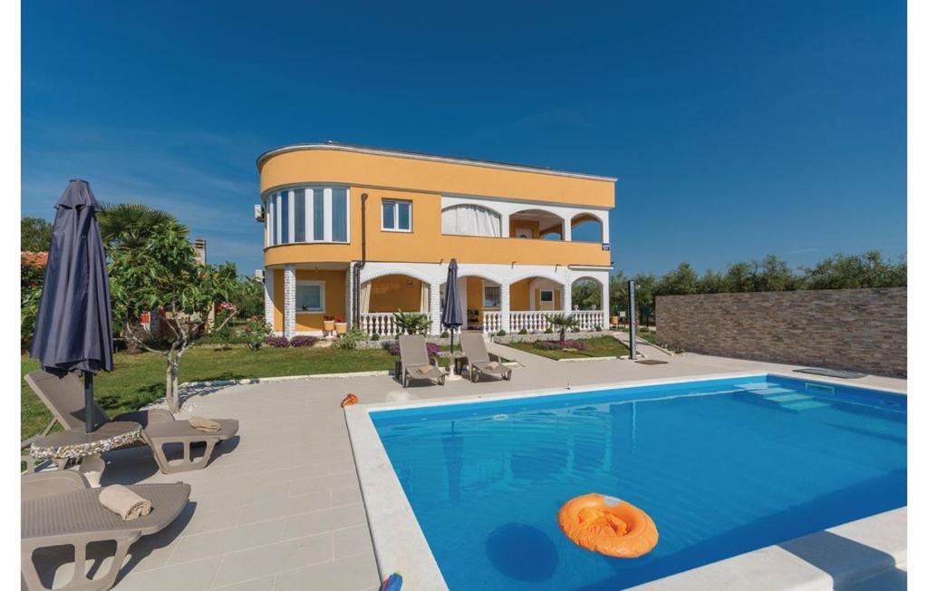 a villa with a swimming pool in front of a house at Apartments Vukancic in Novigrad Istria
