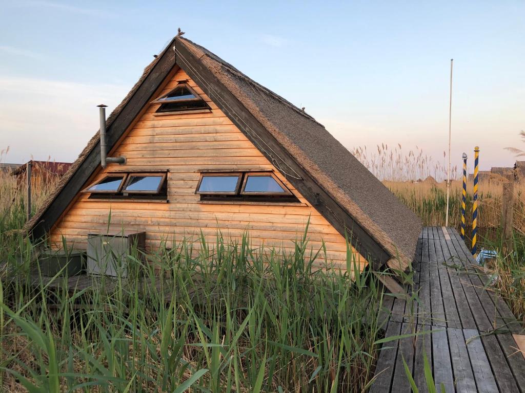 ein kleines Holzhaus mit einem Strohdach in der Unterkunft Pfahlbau Rust Robinsonhütte in Rust