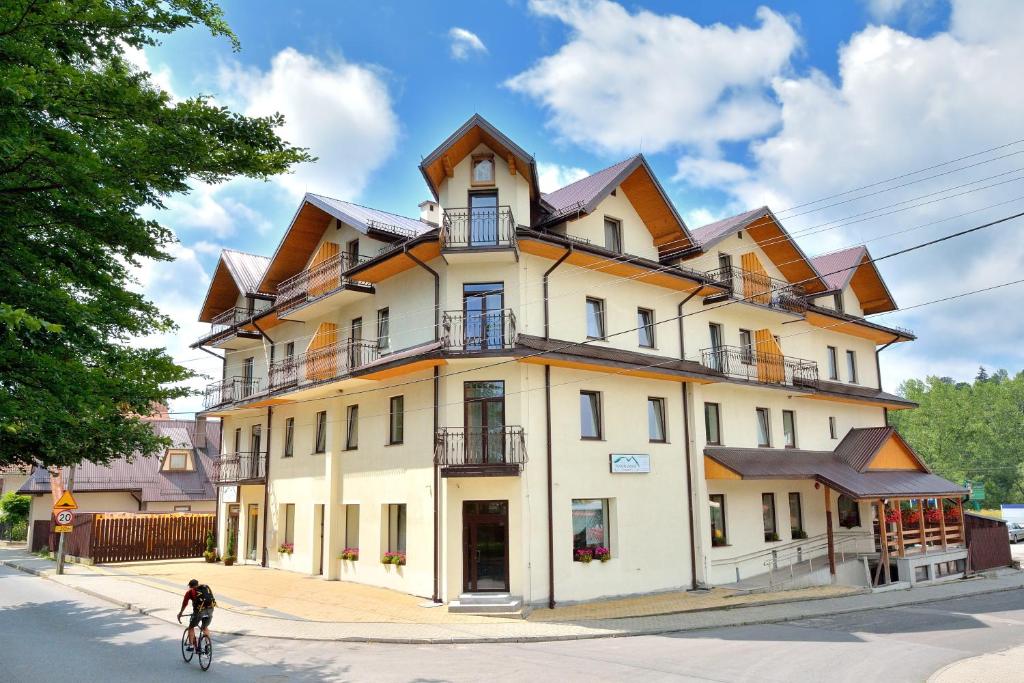 a person riding a bike in front of a building at DW Poronianka in Poronin