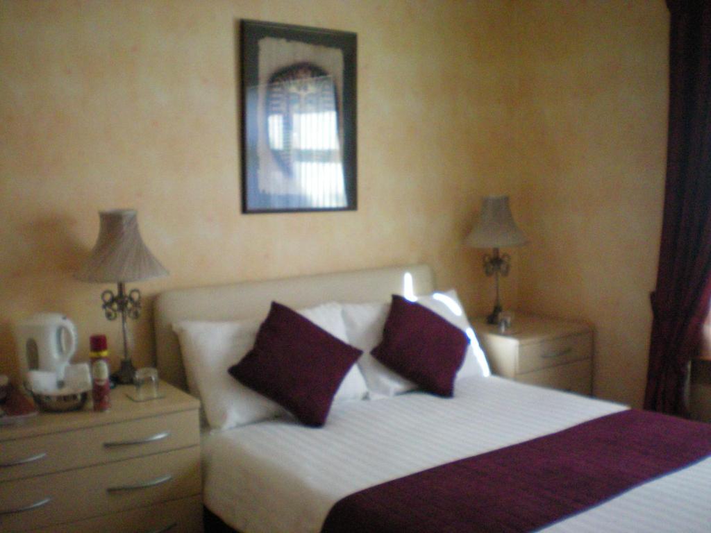 una camera con un letto con due comodini e due lampade di Wimberley House a Inverness