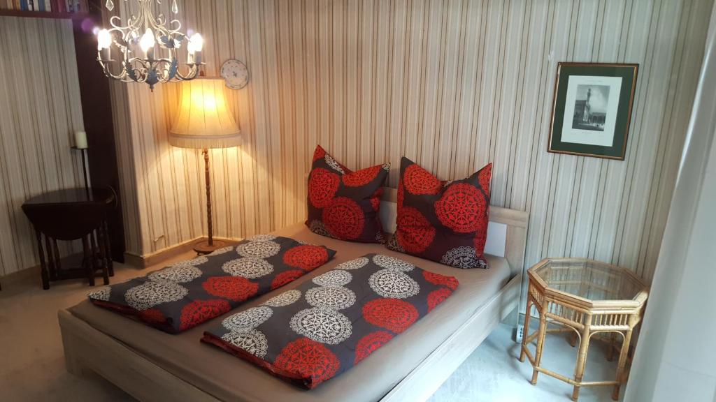 ギュンツブルクにあるMarktplatz Ferienwohnungのベッドルーム1室(赤と黒の枕が付くベッド1台付)