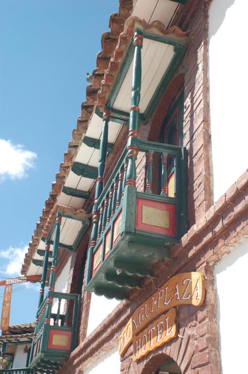 a building with a clock mounted to the side of it at Mongui Plaza Hotel in Monguí