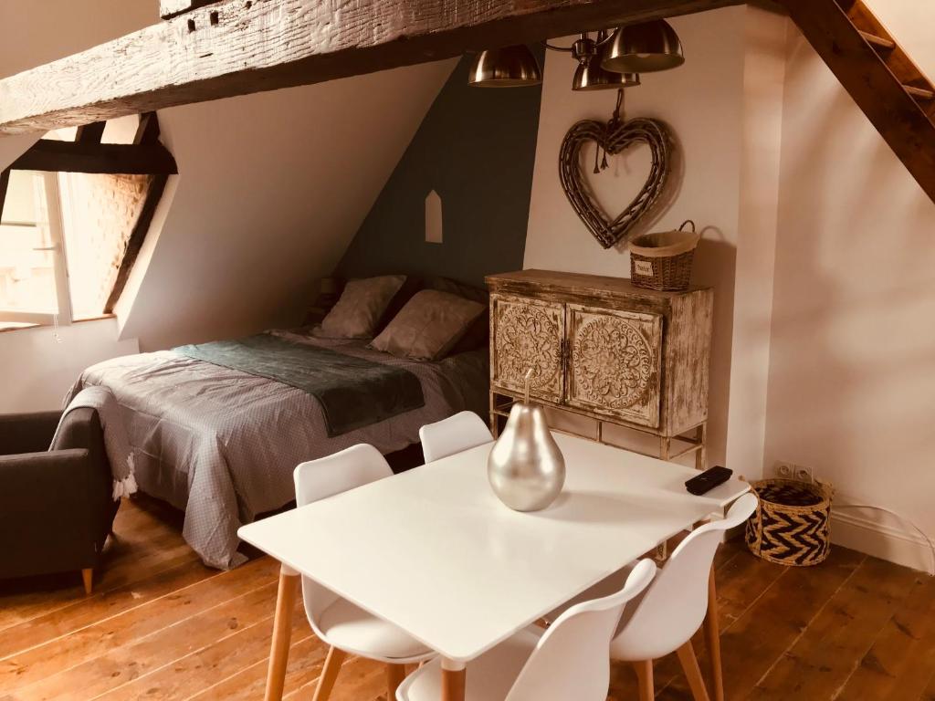 1 dormitorio con 1 cama, mesa y sillas en Comme à la maison, en Boulogne-sur-Mer