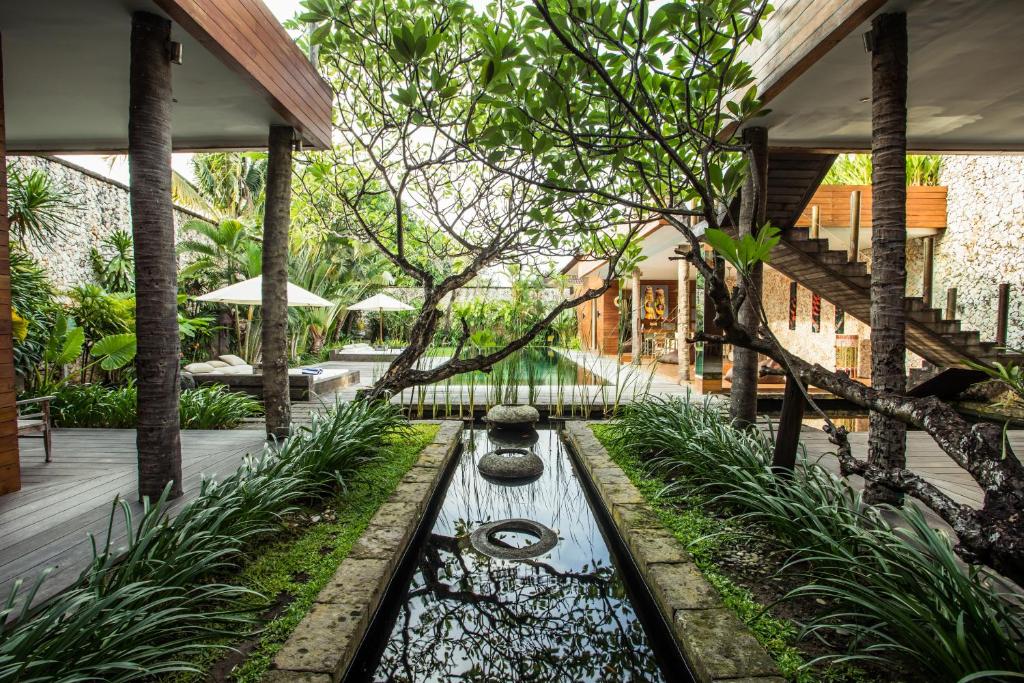 a garden with a pond in the middle of a house at Eko Villa Seminyak in Seminyak