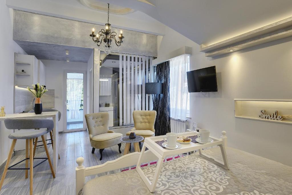 een woonkamer met een tafel en stoelen bij Apartments Zanetti 2 in Pula