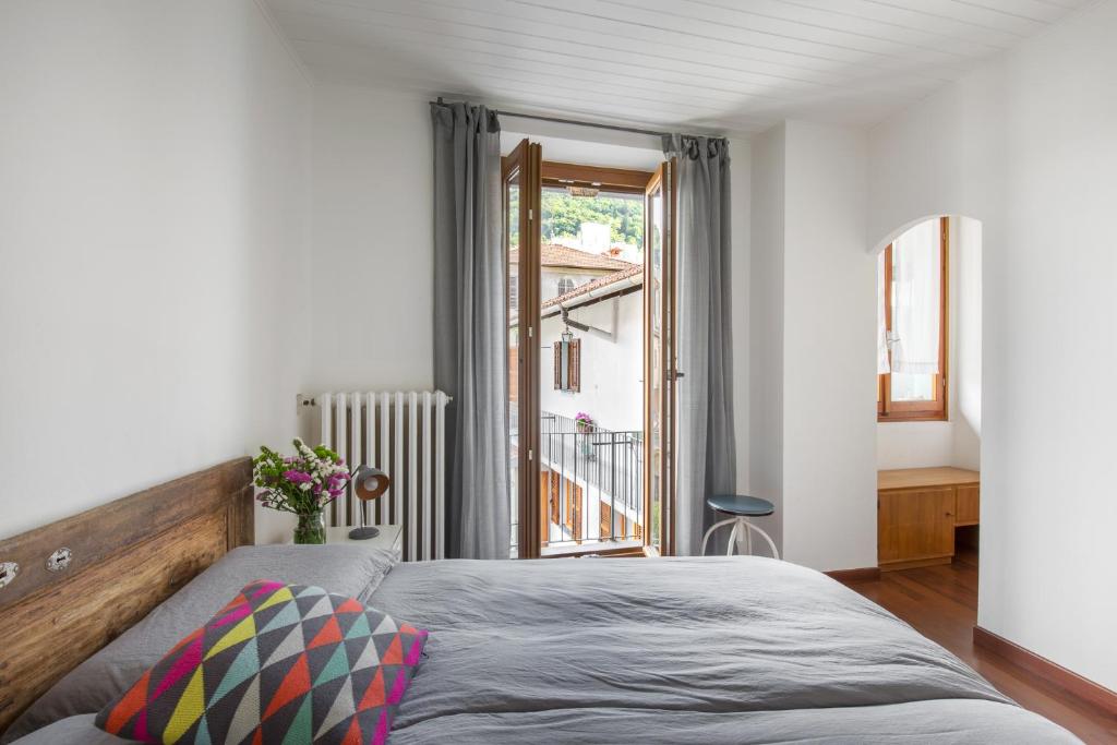 1 dormitorio con cama y ventana en Casa Rina, en Cannobio