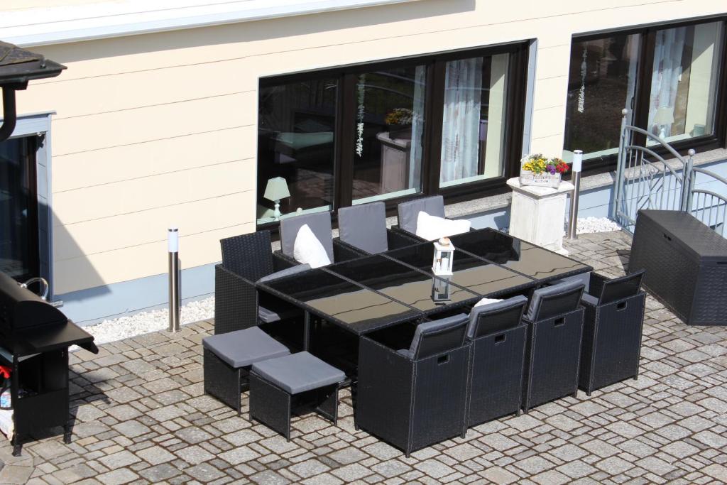einen schwarzen Tisch und Stühle auf einer Terrasse in der Unterkunft Ferienhaus "Am Backes" in Gefell