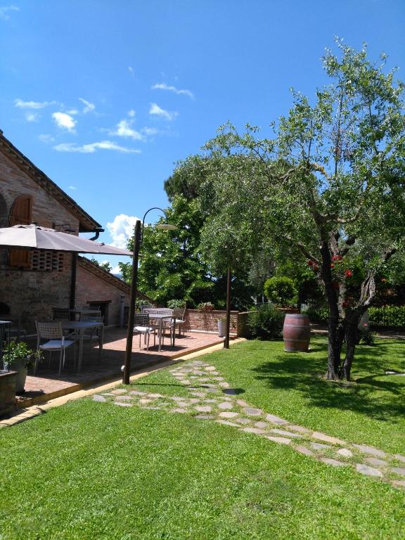 a garden with a table and chairs and a tree at Villa San Michele in Barberino di Val dʼElsa