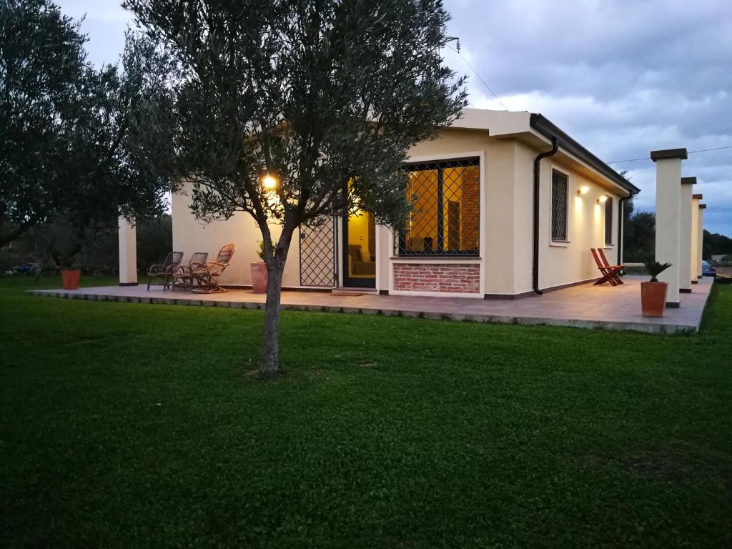 a small house with a tree in a yard at I due Ulivi - strada per La Caletta in Siniscola