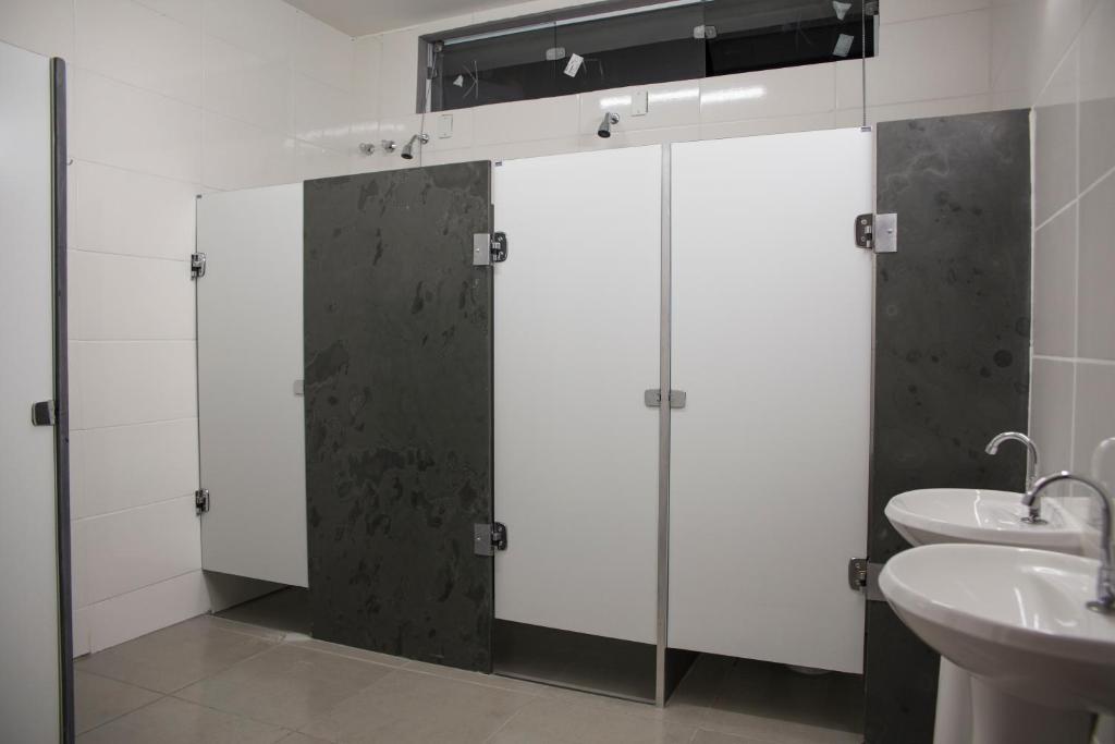 La salle de bains est pourvue de 4 stalles et d'un lavabo. dans l'établissement Vhostel, à Uberlândia