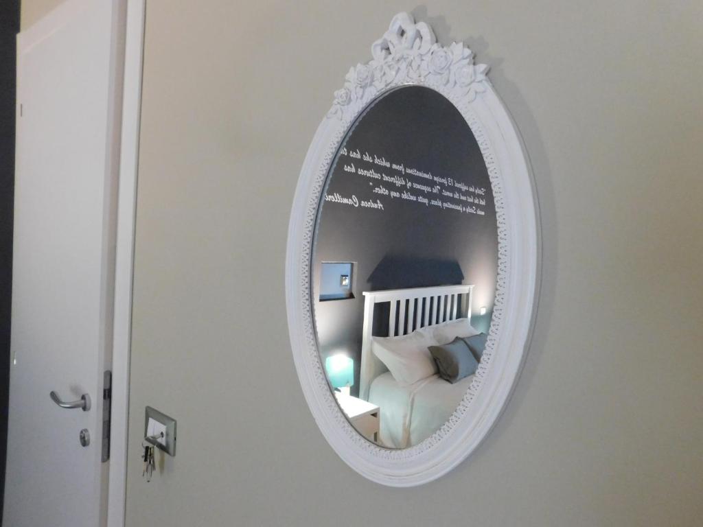 a white mirror on a wall with a bedroom at Corte dei medici - Palace in Catania