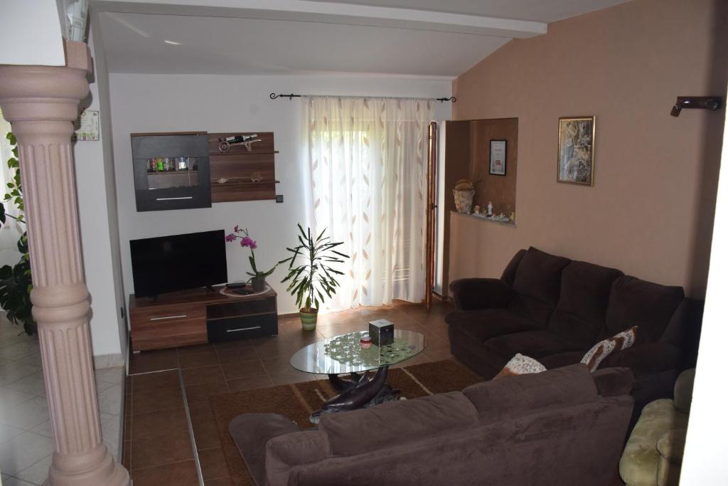ein Wohnzimmer mit einem Sofa und einem Tisch in der Unterkunft Manuela in Ližnjan