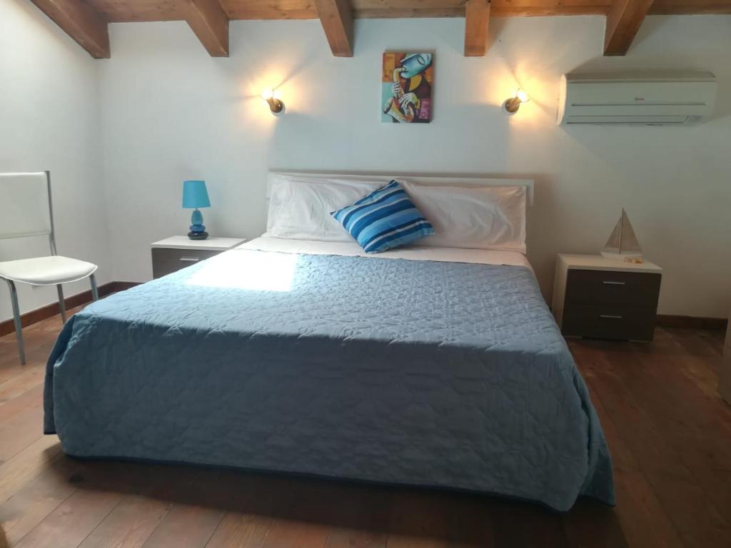 a bedroom with a bed with a blue pillow on it at U Scogghiu Residence in Lampedusa