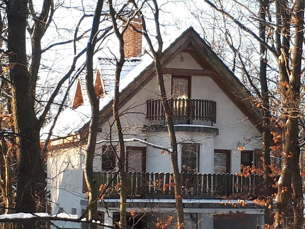 Casa blanca con balcón en la nieve en Csalavér-Vendégvadászház, en Noszvaj