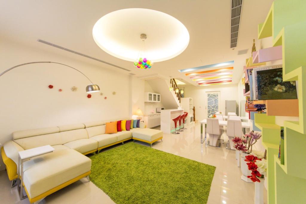 uma sala de estar com um sofá e um tapete verde em Pure B&B em Hualien City