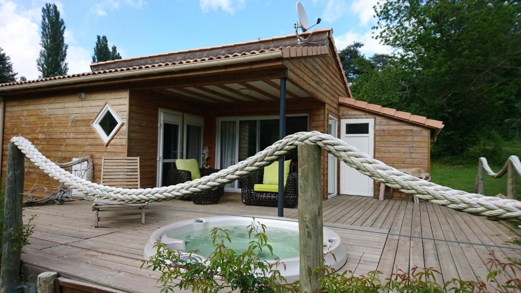 a wooden deck with a hot tub and a house at Camping le Soleil in Vivario