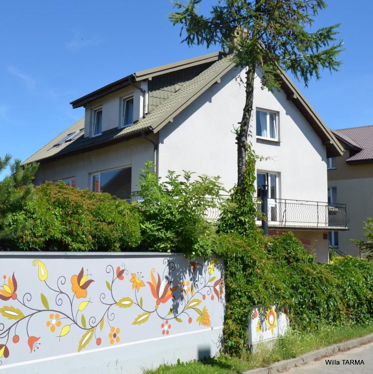 a house with a fence and a tree at Willa Tarma in Władysławowo