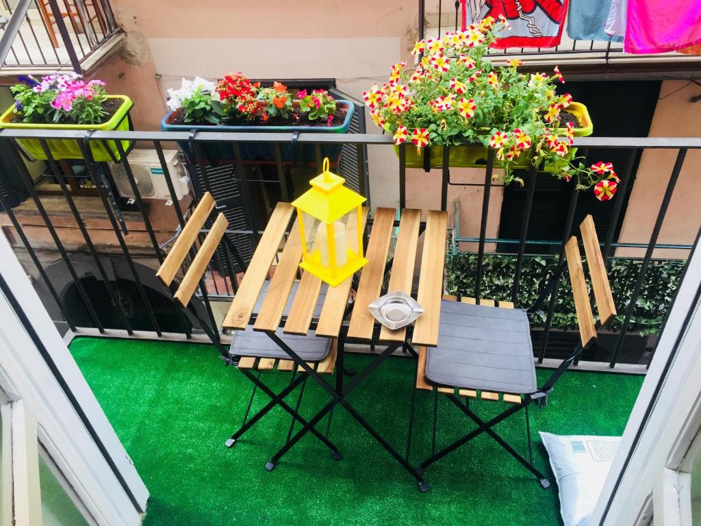 einen Tisch und Stühle auf einem Balkon mit Blumen in der Unterkunft Rita's home in Neapel