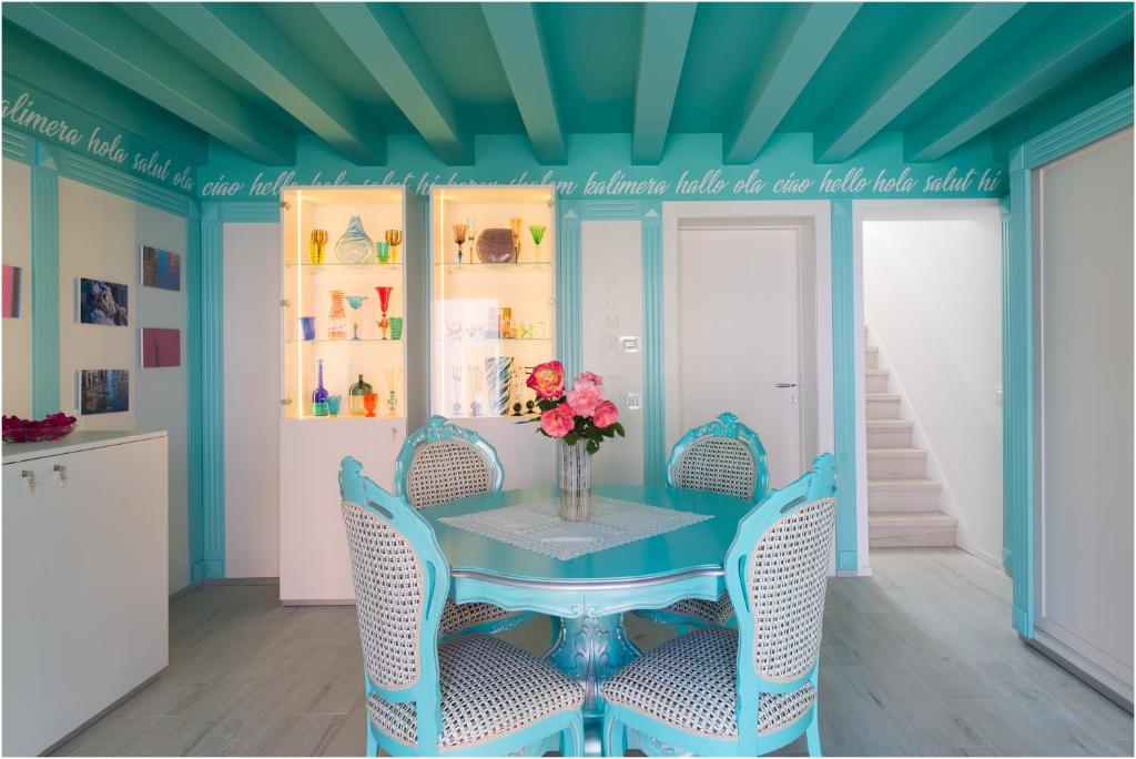 una sala da pranzo blu con tavolo e sedie di Tiffany Home a Burano