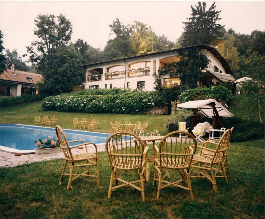 um grupo de cadeiras em torno de uma mesa em frente a uma casa em Il giardino di Raffaella em Montorfano