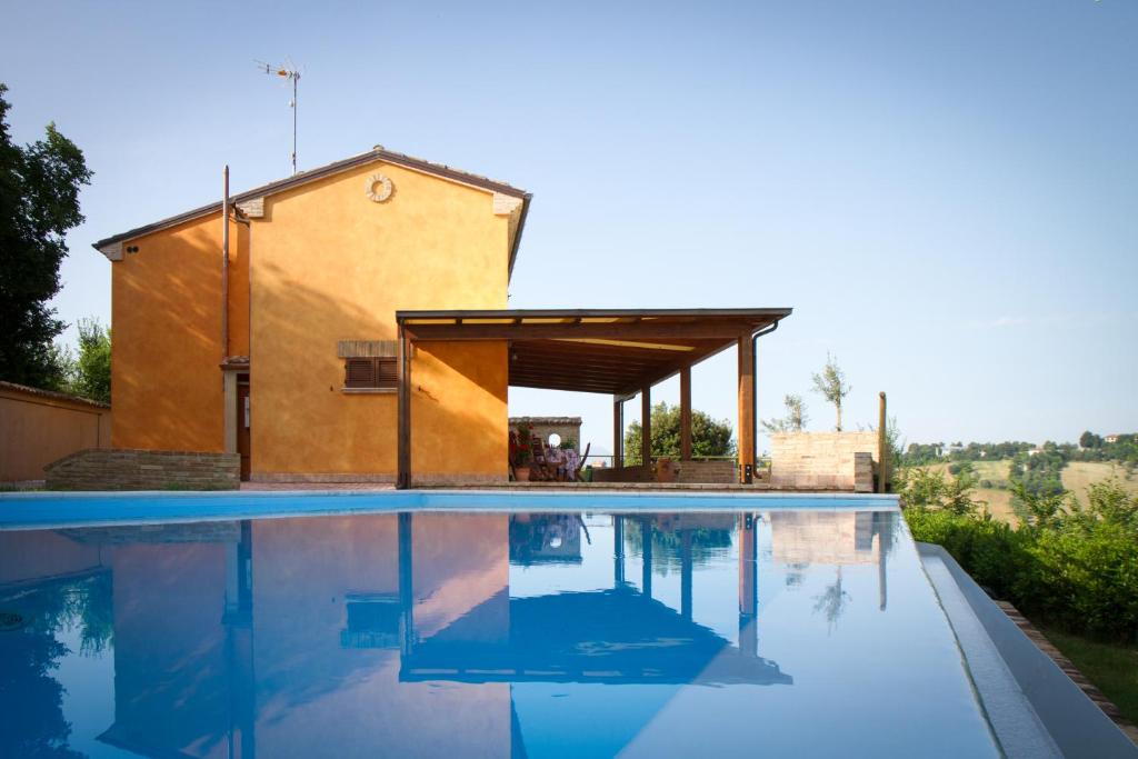 a house with a swimming pool in front of a building at Il Gladiolo in San Marcello