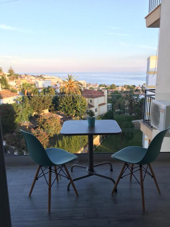 ラ・カラ・デル・モラルにあるSunny Apartmentsのテーブルと椅子2脚、景色を望むバルコニー