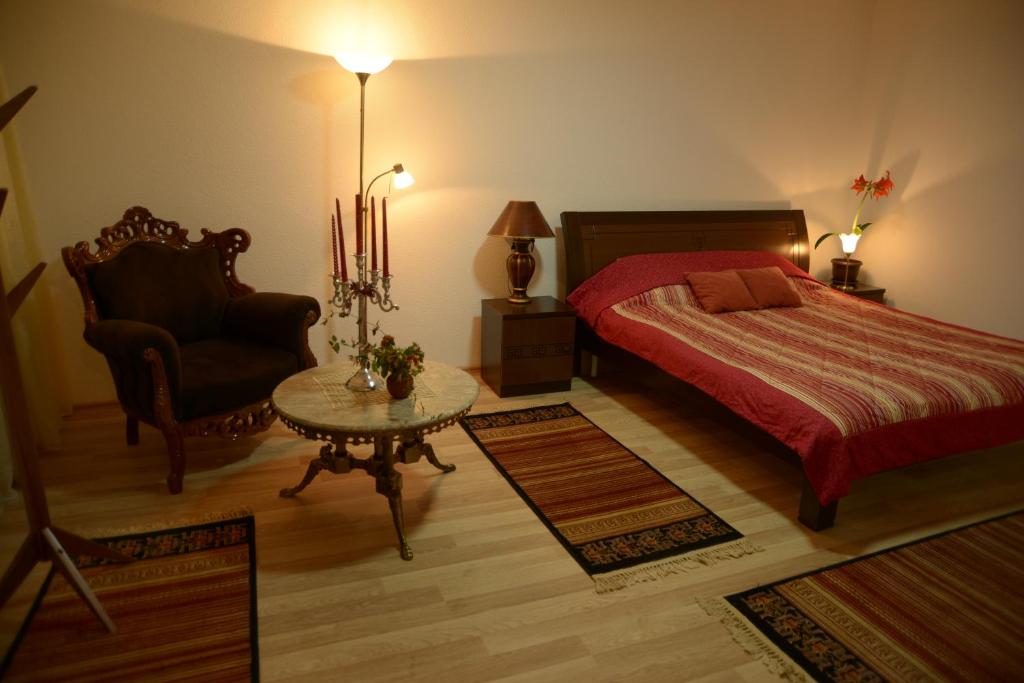 a bedroom with a bed and a chair and a table at Hostel Tuba in Pristina
