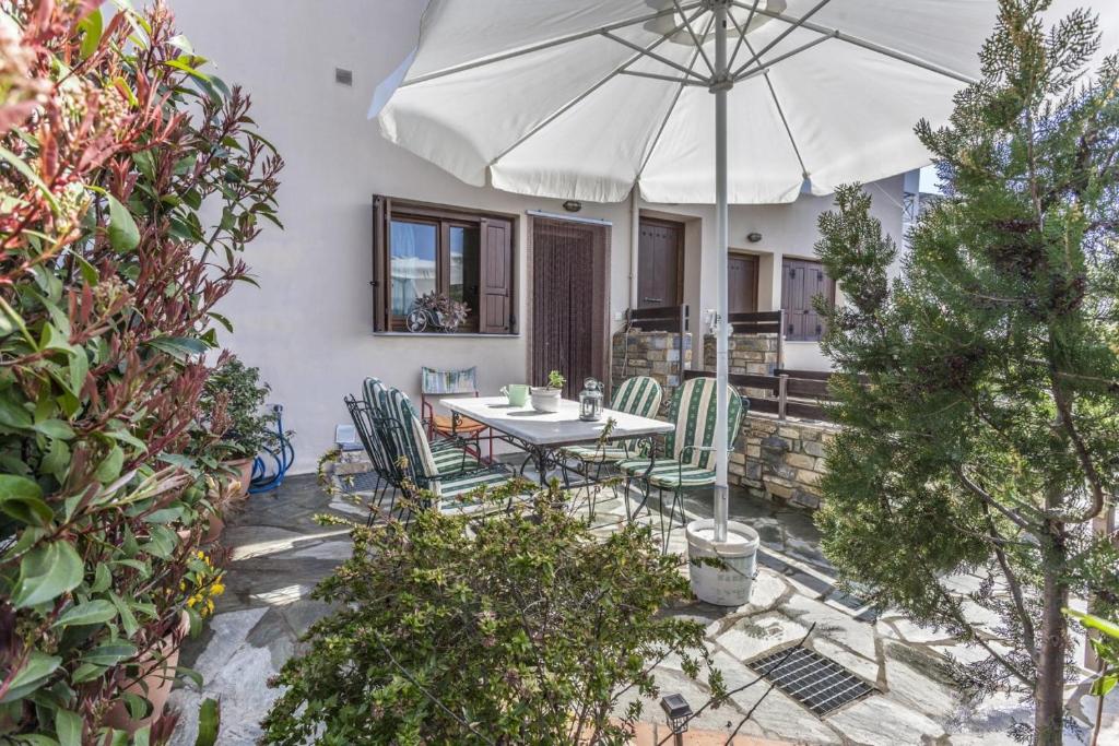 a patio with a table and chairs and an umbrella at Rena's House Afissos in Afissos