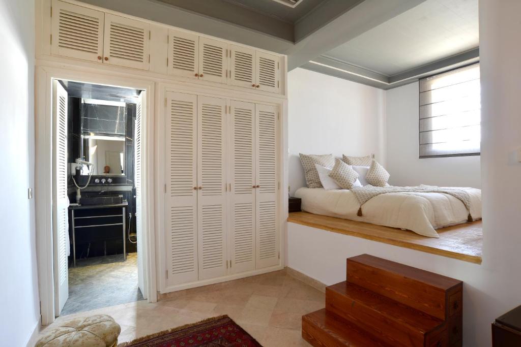 a bedroom with a bed sitting on a wooden bench at Palais Bayram in Tunis
