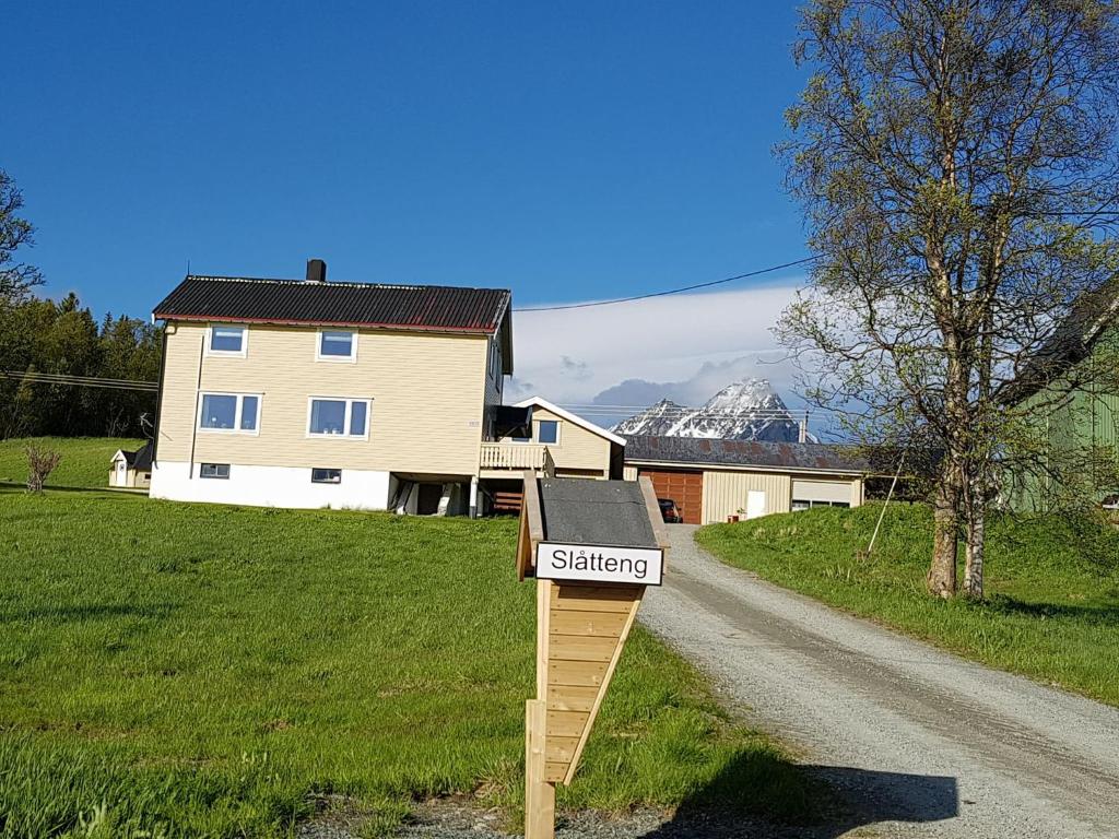 ein Schild auf einer Straße vor einem Haus in der Unterkunft Slåtteng in Svensby