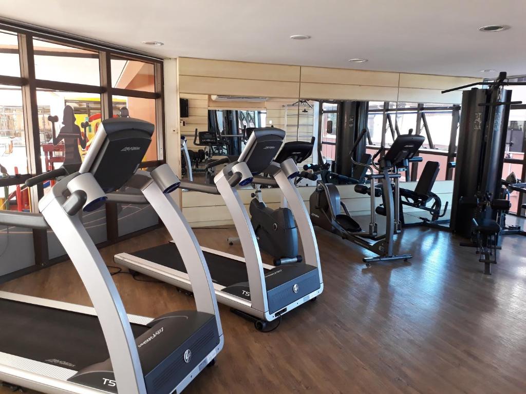 a gym with treadmills and elliptical machines at ApartHotel no Jurerê Beach Village in Florianópolis