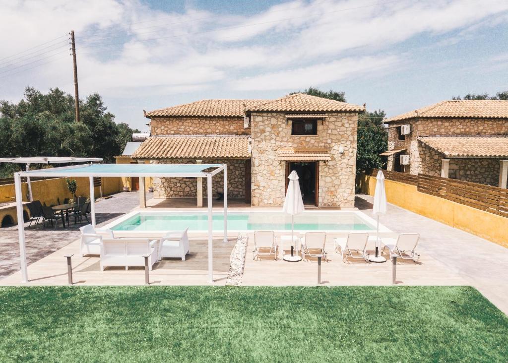 a villa with a swimming pool in front of a house at Villa Dimitris in Laganas