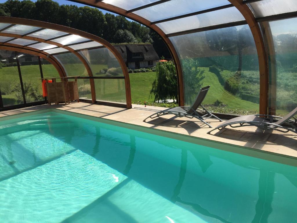 a swimming pool with two chairs in a house at Holiday home Le clos du phare in Saint-Samson-de-la-Roque