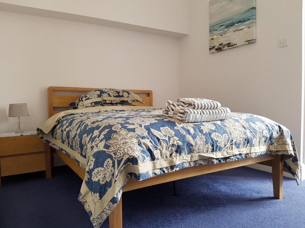 a bedroom with a bed with a blue and white comforter at Alexandra Lodge Guest House in Chester