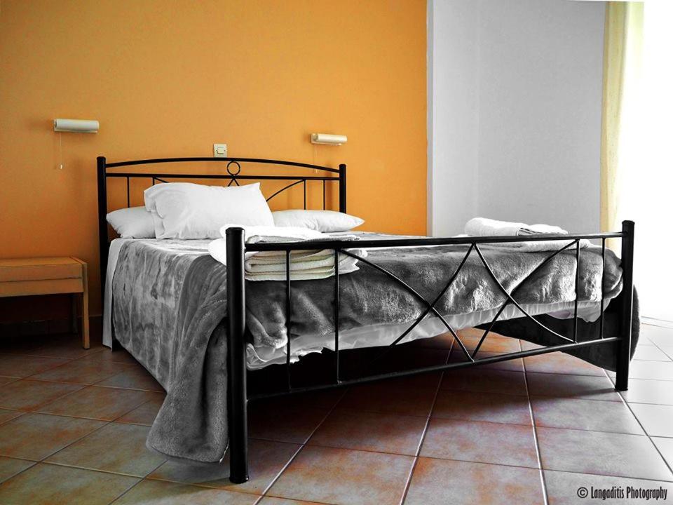 a bed with a black frame in a room at Yaliskari Beach in Pelekas